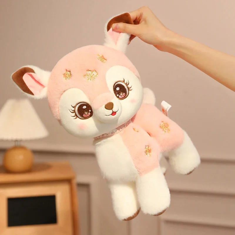 kawaii pink deer plushie being held by its ear.