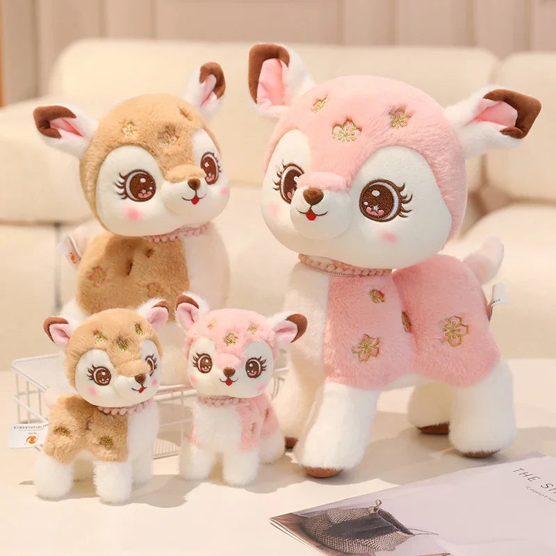 Set of four plush deer toys in various sizes on a light background