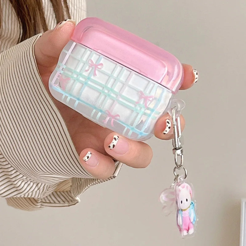 Pink and clear case with bow design held by a person, featuring a cat charm.