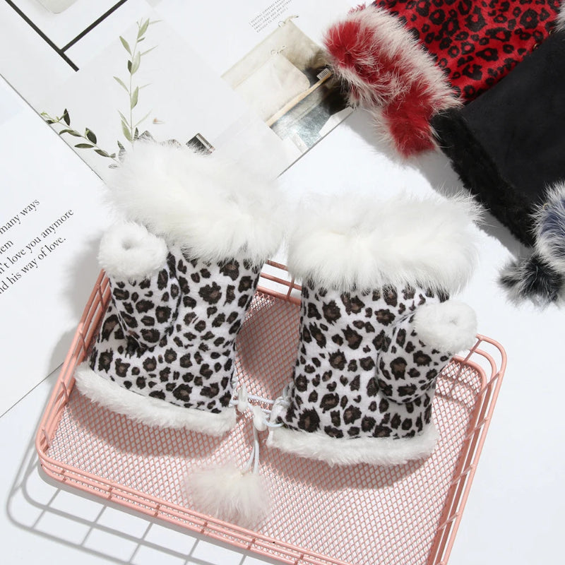Pair of leopard print gloves with white fur trim on a pink metal tray.