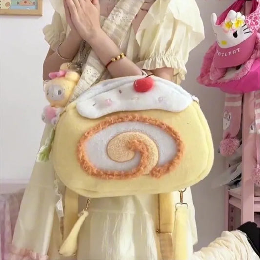 Person holding a plush pastry bag with a cherry on top, surrounded by other plush toys.