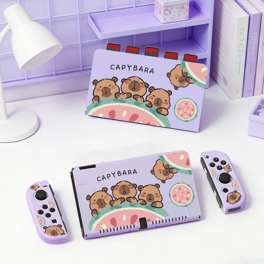 kawaii capybara watermelon switch case, this is the pastel purple version with three capybaras holding onto a watermelon while displaying different happy expressions on their faces, this is shown on a white desk.