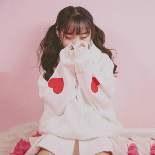 Model With Hands Over Her Mouth Wearing Heart Sleeve Hoodie Pullover