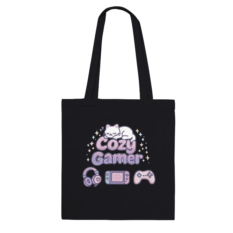 Black tote bag with 'Cozy Gamer' design featuring a cat, gaming console, and controller on a white background.