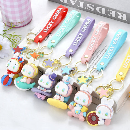 Lucky Emma Baby Keychains , the different designs displayed against a stack of books