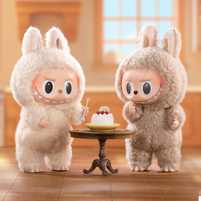 Two blind box plush toys istanding next to a small table 