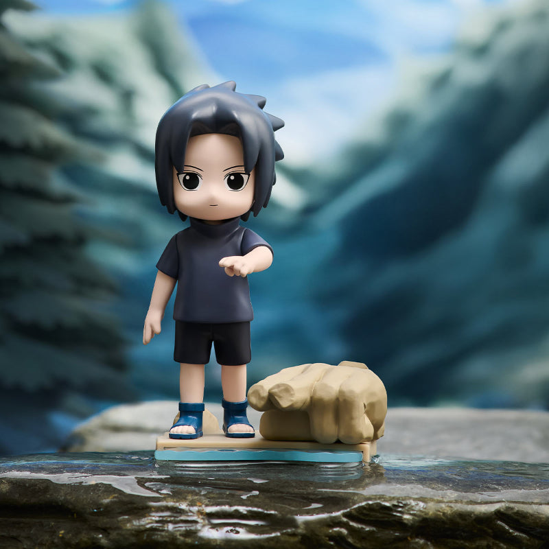 Toy figure of a character with dark hair and a fist on a blurred natural background