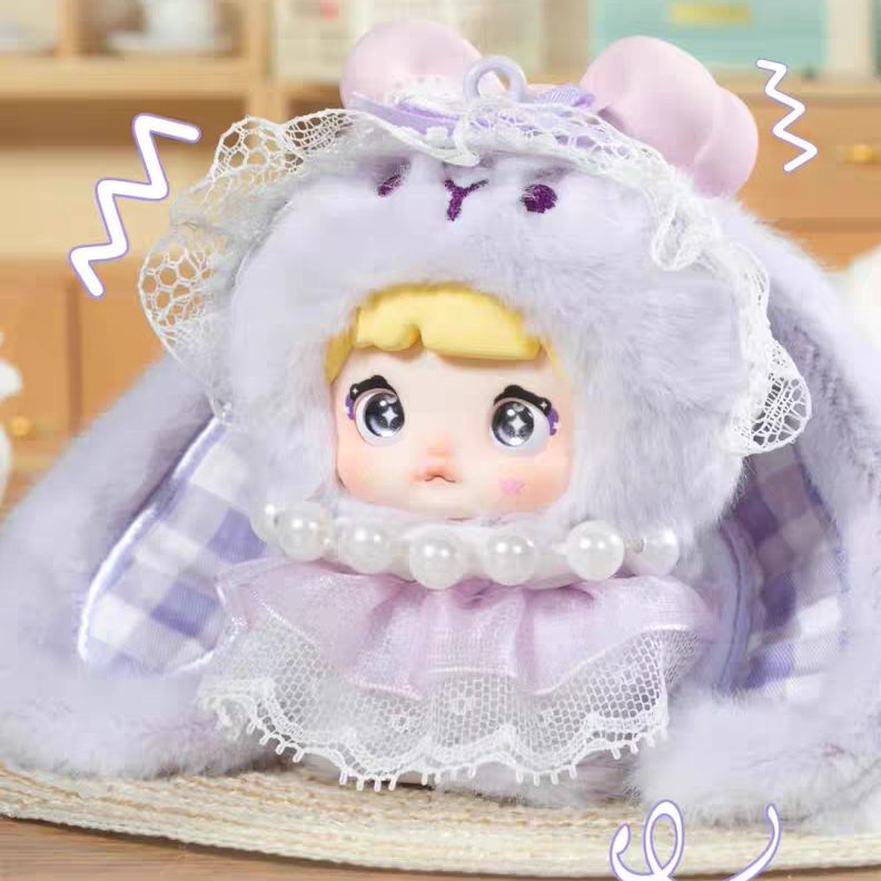   kawaii blind box plush toy with a purple outfit and white cape on a wooden surface.