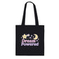 Black tote bag with 'Dream Powered' text and kawaii celestial designs on a white background