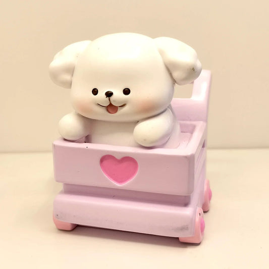White animal in a pink toy car with a heart on a beige background