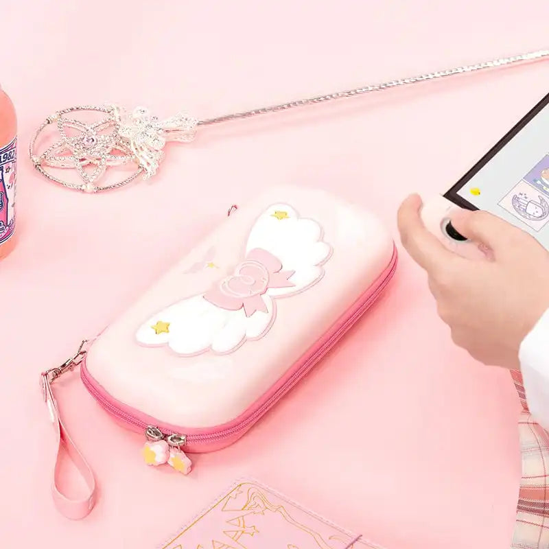 Pink Nintendo Switch case with kawaii wings design on a pink background
