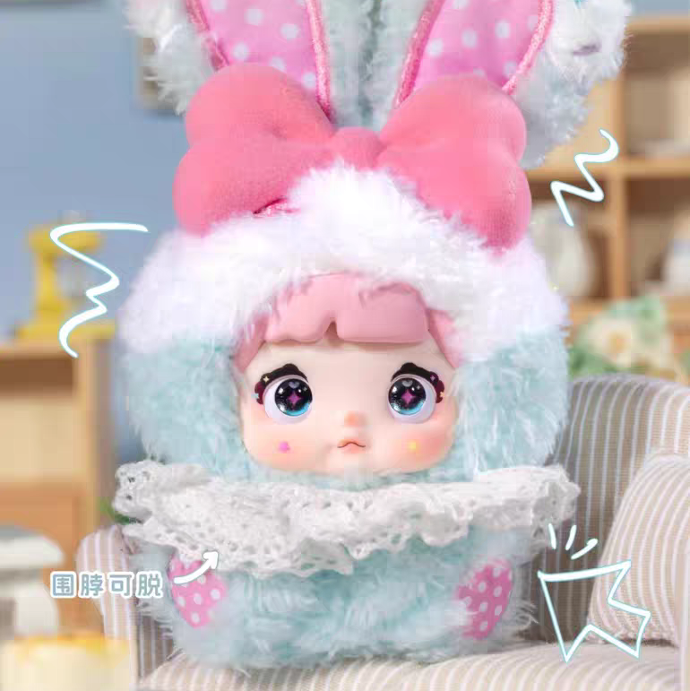 Toy figure with bunny ears and a bow on a blurred indoor background