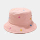 Pink bucket hat with colorful flower patterns on a light gray background