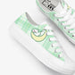 Pair of green and white sneakers with kawaii design on a white background