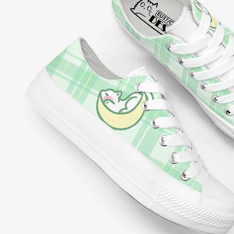 Pair of green and white sneakers with kawaii design on a white background