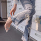Person wearing pearl-embellished jeans and high-heeled shoes indoors.