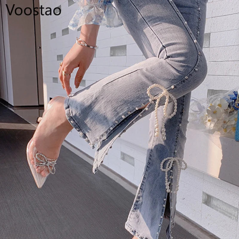 Person wearing pearl-embellished jeans and high-heeled shoes indoors.