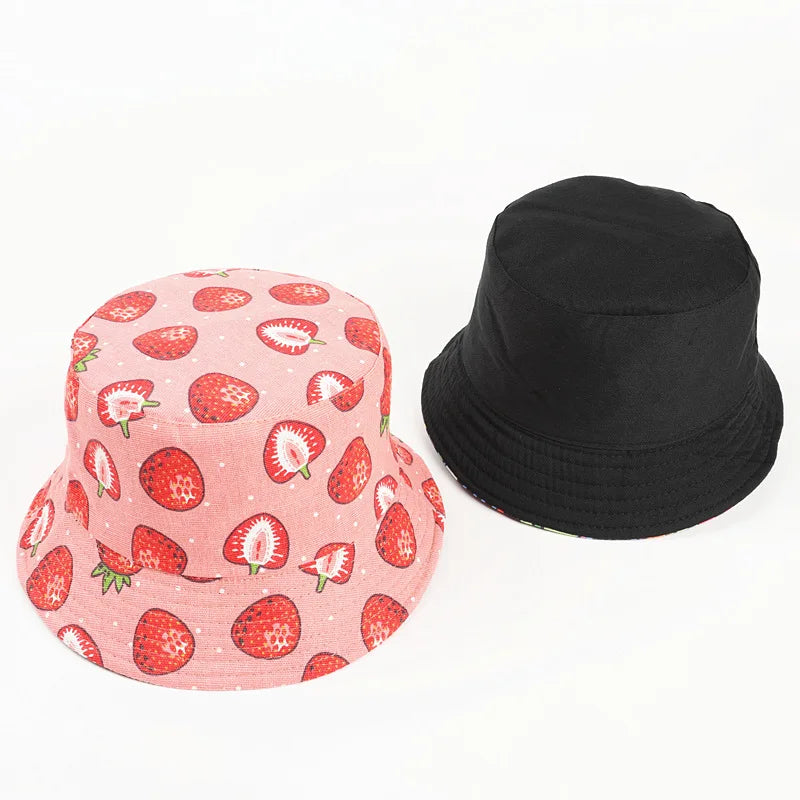 Pink bucket hat with cute strawberry pattern and black bucket hat on a white background