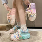 Kawaii pastel pearl sneakers being displayed by a person wearing them and also holding a pair
