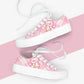Pink kawaii sneakers with cute cat designs on a pink and white striped background