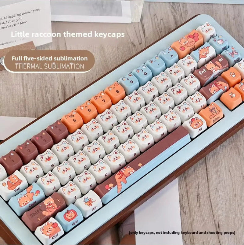 Keyboard keycaps with cute red panda designs in a box on a wooden surface.