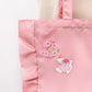 Kawaii Cherry Blossom Iron-On Embroidery Patches are displayed on a pink tote bag , the white bird with the blossoms on the wings and the blossom wreath designs.