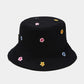 Black bucket hat with colorful flower patterns on a light grey background