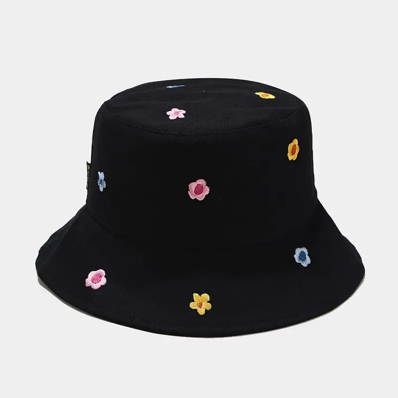 Black bucket hat with colorful flower patterns on a light grey background