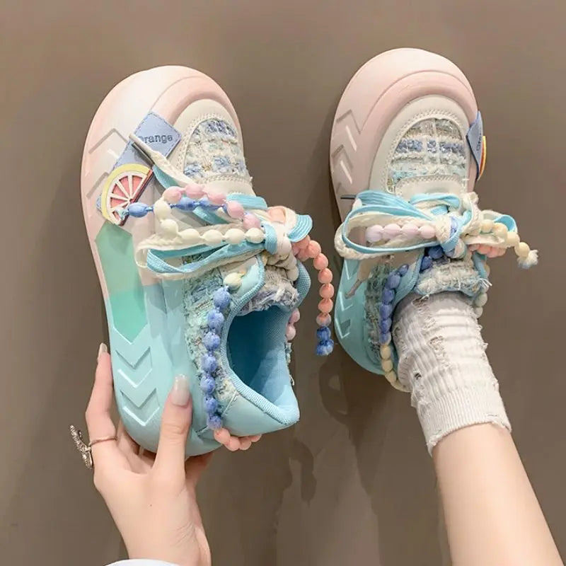 Pair of Kawai pastel Sneakers with decorative Pearl elements on a brown background, blue version