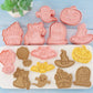 Set of Halloween-themed cookie cutters on a blue wooden surface with a plant in the corner.