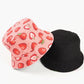 Pink bucket hat with strawberry pattern and black bucket hat on a white background