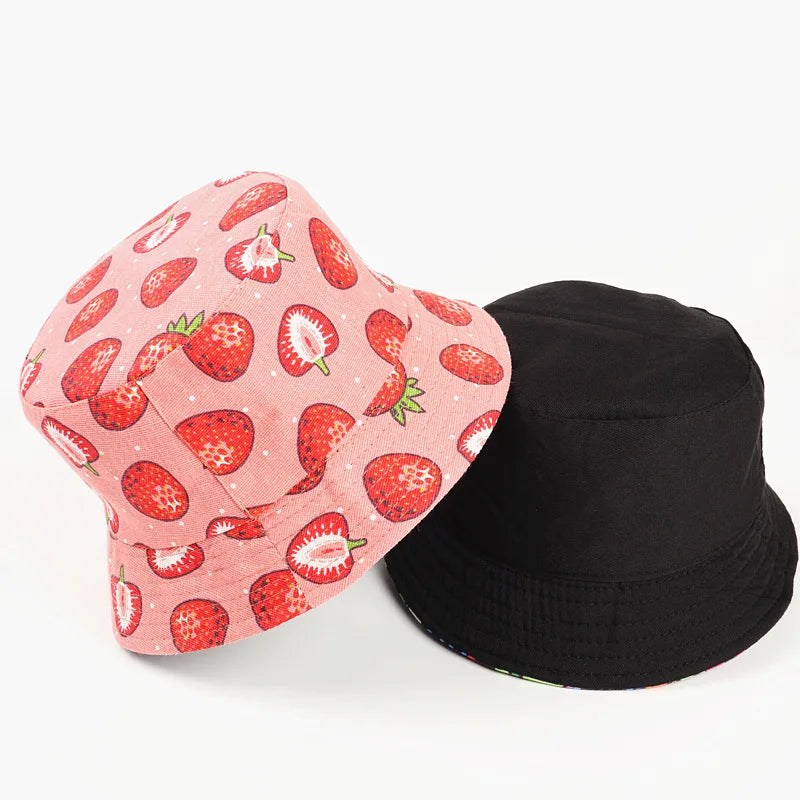 Pink bucket hat with strawberry pattern and black bucket hat on a white background