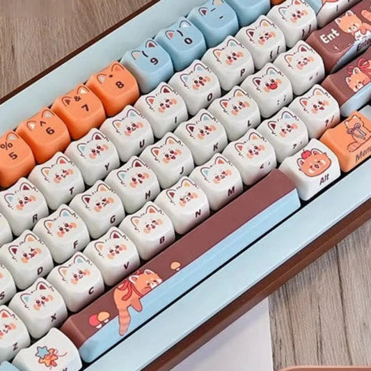 Keyboard keycaps with red panda design on a wooden surface