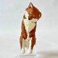 Toy fox figure on a clear stand against a white background