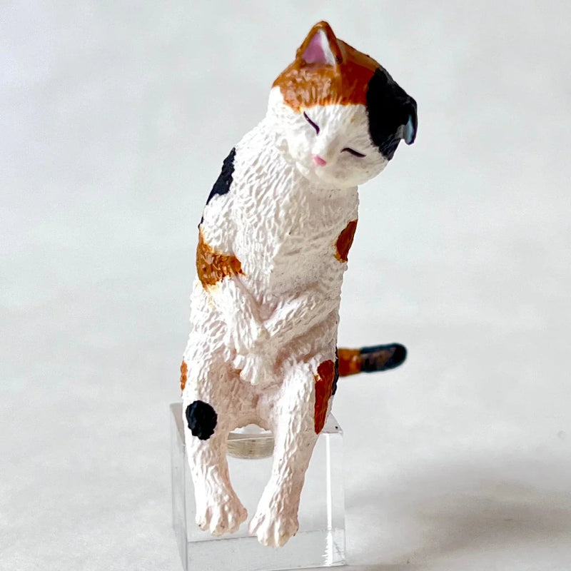 Cat-shaped figurine on a clear stand against a white background