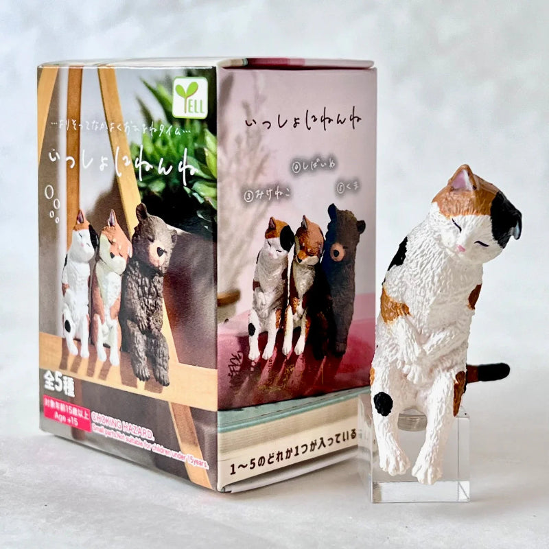 Cat figurine with packaging on a light gray background