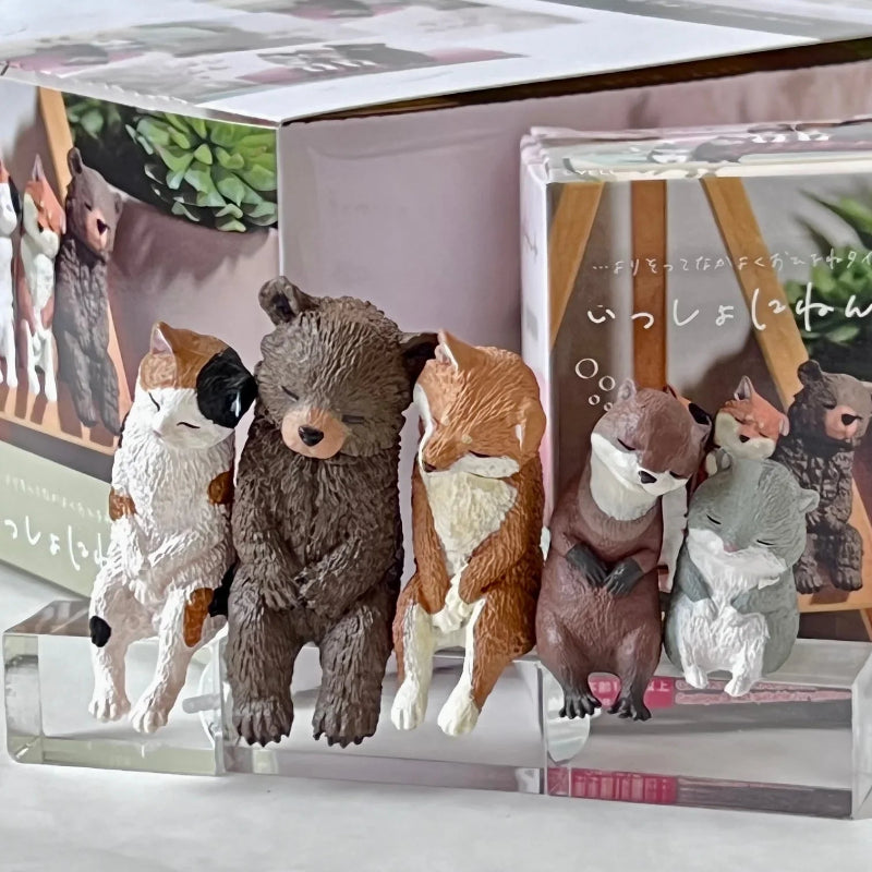 Set of animal figurines on a clear stand with books in the background