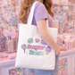 Person holding a tote bag with 'Sugar Rush' design in a candy store.