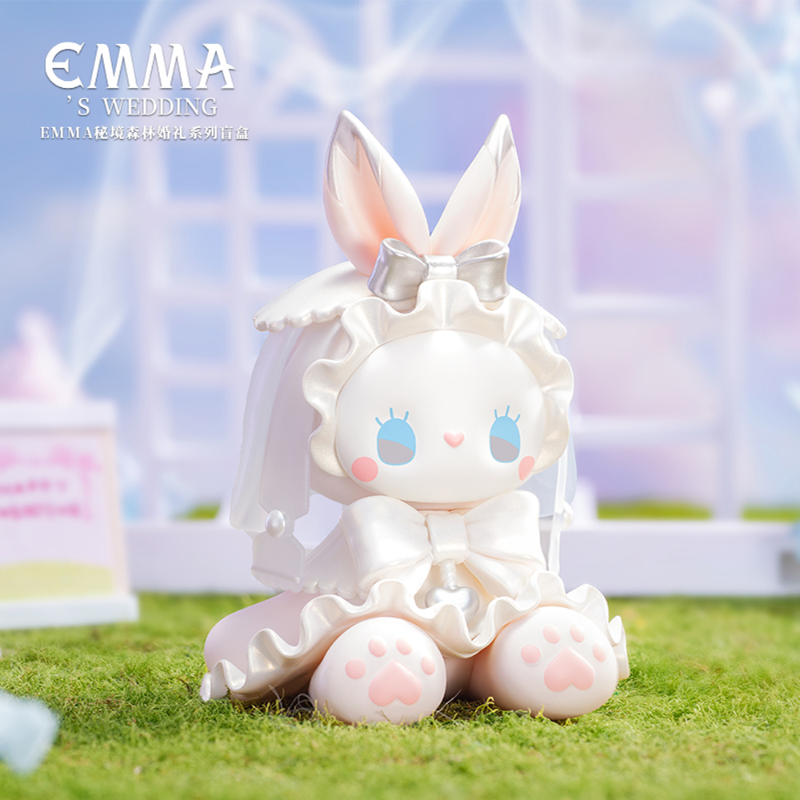 Kawaii rabbit figurine with a bow on grass, 'EMMA'S WEDDING' text in the corner.