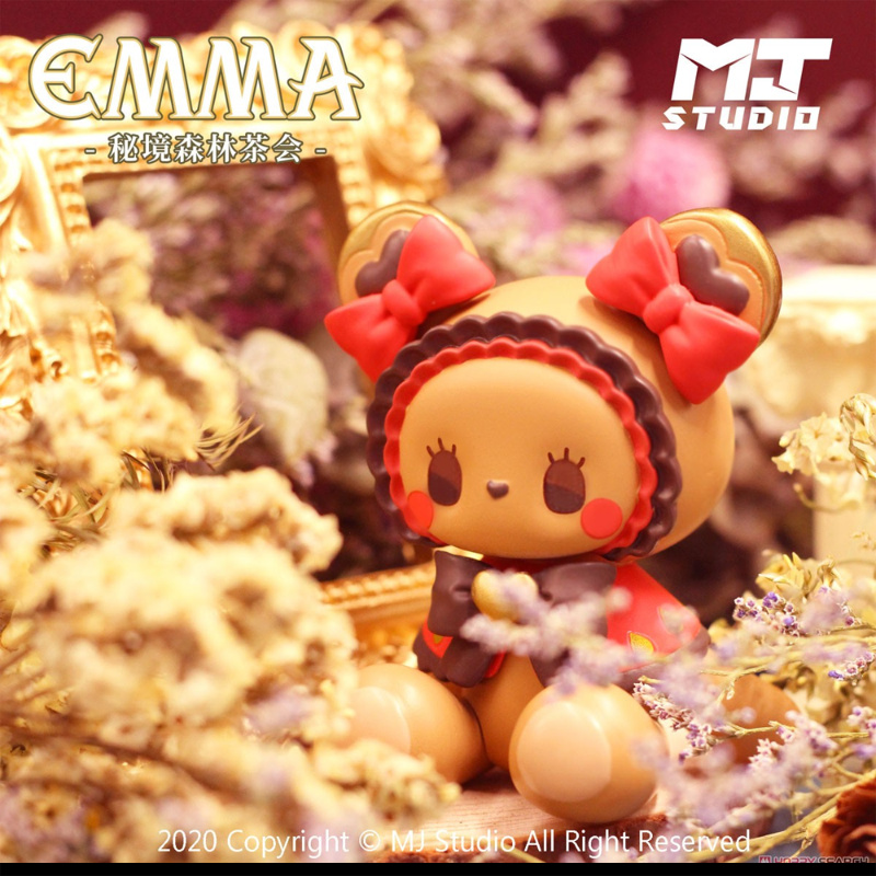 Toy figure with red bows on a decorative background with 'MT Studio' branding.