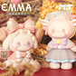 Two cute figurines with large bows, one held by a hand, on a decorative background with 'EMMA' and 'MT Studio' branding.