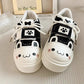 Pair of cute neko white sneakers with black accents and cute face designs on a neutral background