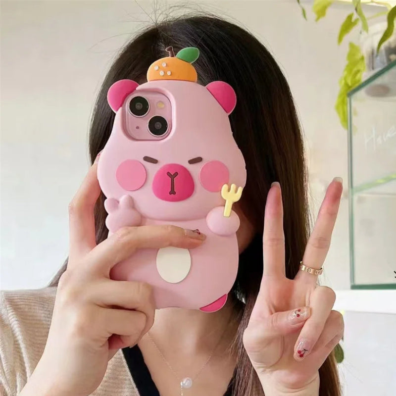 Person holding a pink capybara phone case with a two-finger peace sign gesture.