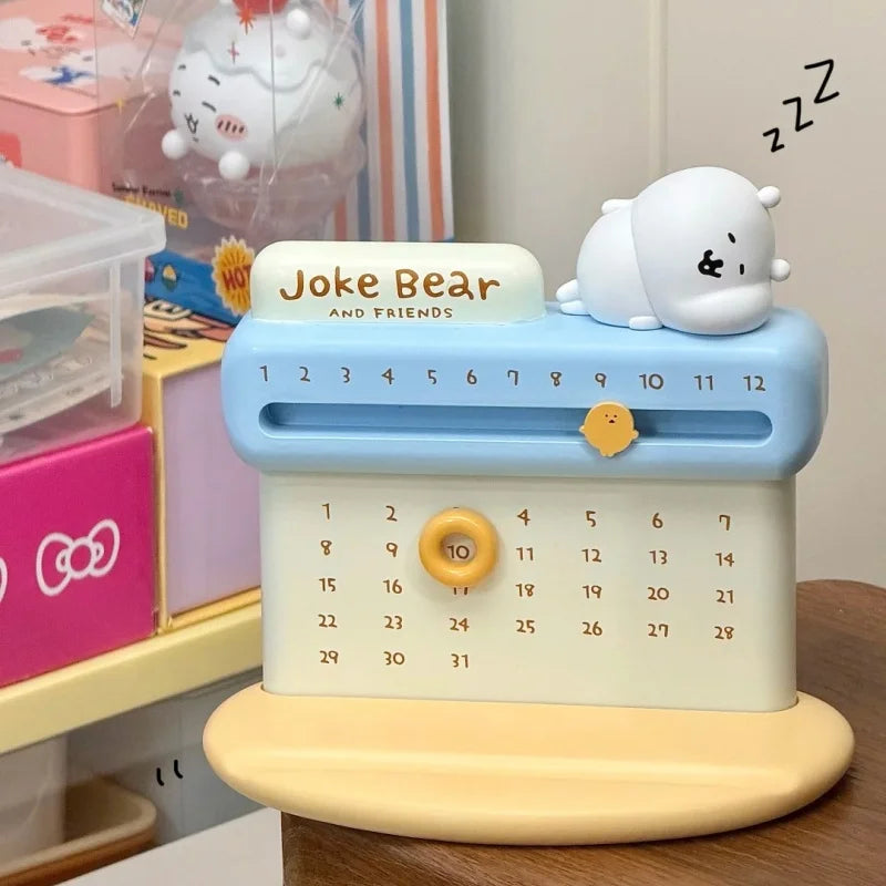 Calendar with a bear design and 'Joke Bear' text on a wooden surface.