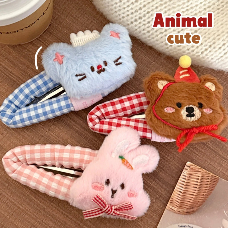 Three kawaii plush animal-themed hair clips on a wooden surface.