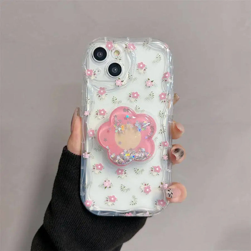 A woman is holding one of the designs available for the Kawaii Cherry Blossom Samsung Phone Case, this design is petite floral patter design with a large cherry blossom phone grip that attaches to it.