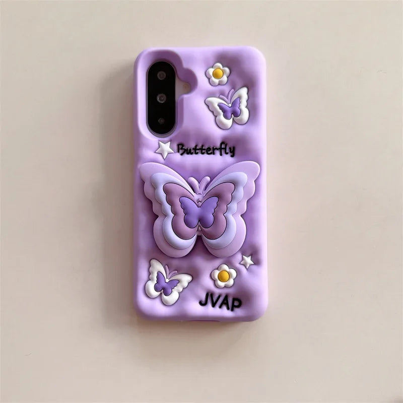 This image is showing Kawaii Butterfly Samsung Phone Case, one option is the purple design with a large 3D butterfly in the middle which is a phone grip, with smaller butterflies around it and some white flowers. 