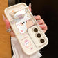 A woman is holding the Kawaii Cuties Samsung Phone Case, showing a closer view of the design of the case which features a sweet cat and a bear as a phone stand, which also includes the mirror when you position its head a certain way.