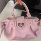 Kawaii Sweet Heart Lock Bag Pink held by a woman on a desk 