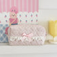 Pink checkered pencil case with a bow on a white surface with a colorful background